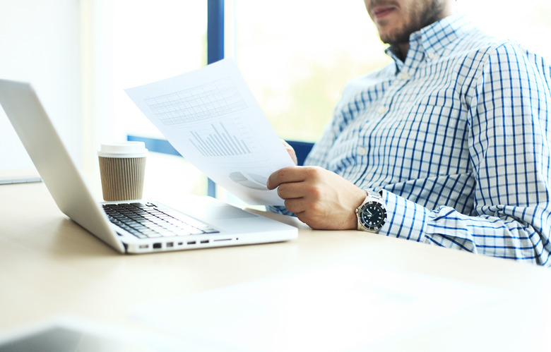 Business man working at office with laptop and documents