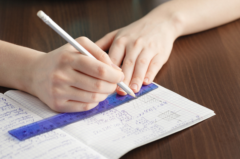 Girl writes in a notebook mathematical formulas