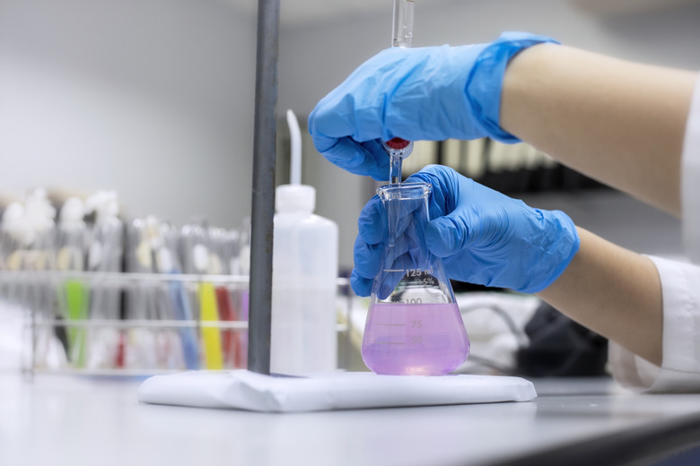 Chemical laboratory concept; Close up of scientist hand use burette for titration in the laboratory