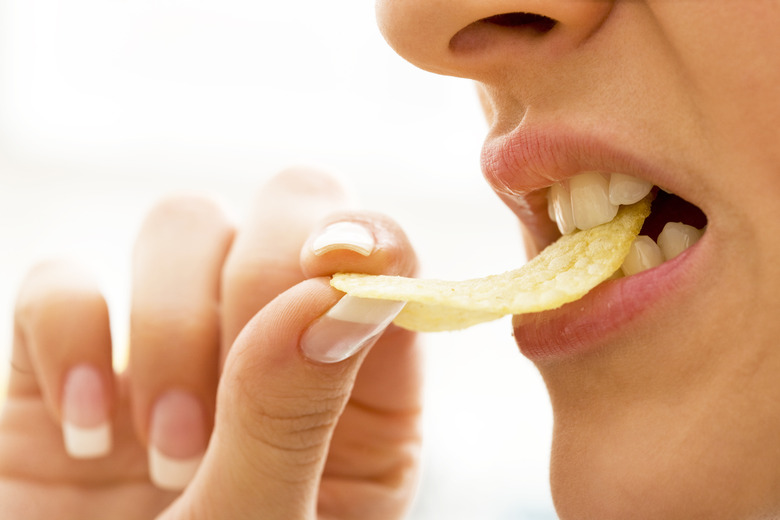 Woman biting potato chips