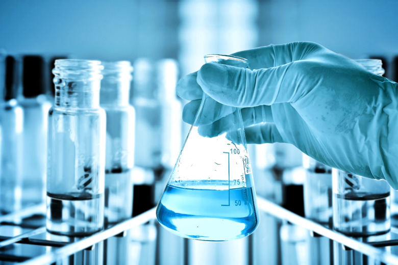 Flask in scientist hand and test tubes in rack