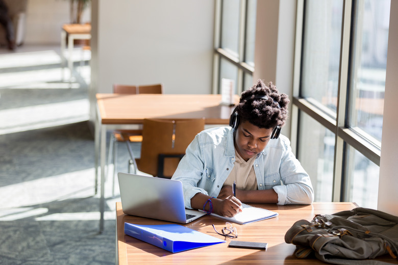 Teenage boy studies in school library