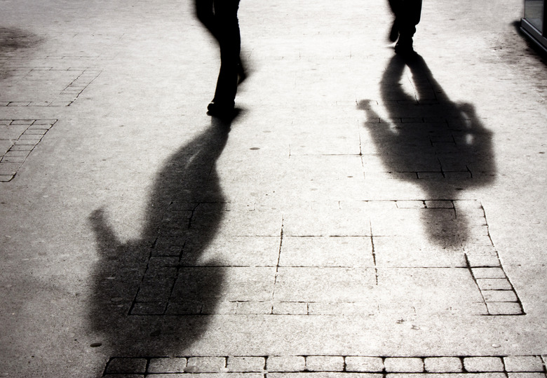 Shadow of a man on patterened sidewalk