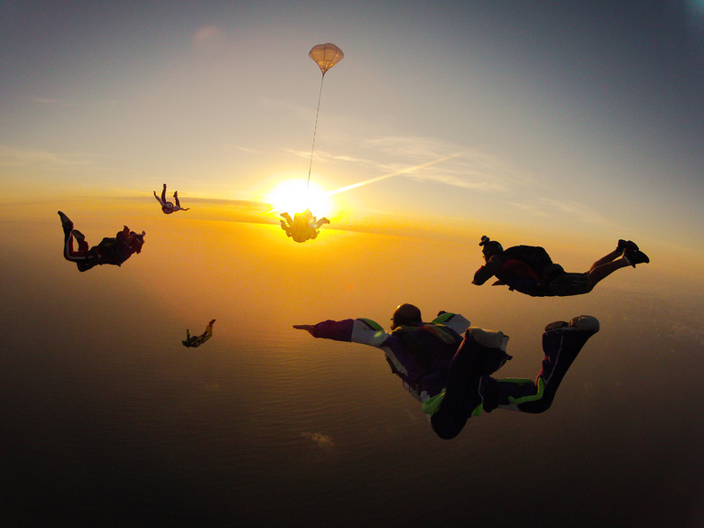 Group of people skydiving at sunset