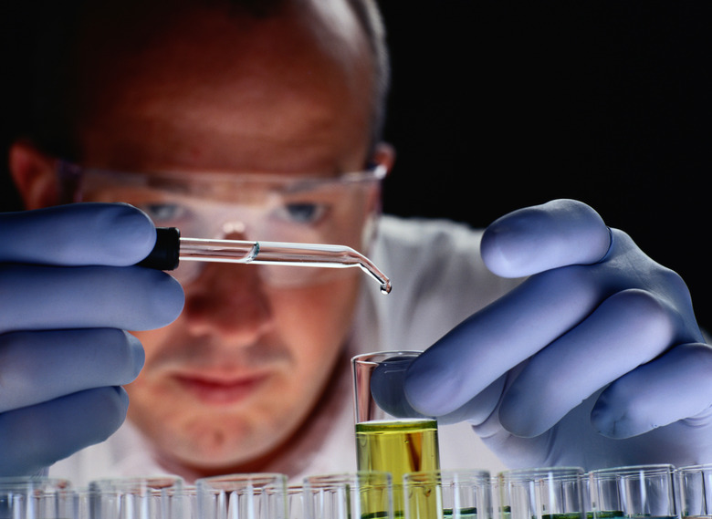 Chemist Dropping Liquid into Test Tubes