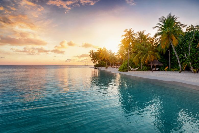 Sunrise behind a tropical island in the Maldives