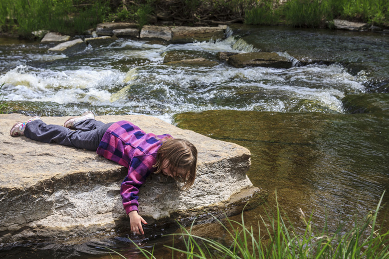 Young Girl Dipping Her Hand in the Water