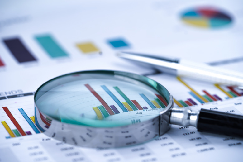 Magnifying glass on charts graphs spreadsheet paper. Financial development, Banking Account, Statistics, Investment Analytic research data economy, Stock exchange trading, Business office company meeting concept.