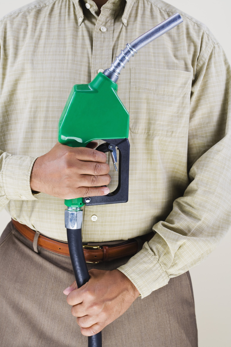 Man holding green fuel pump nozzle