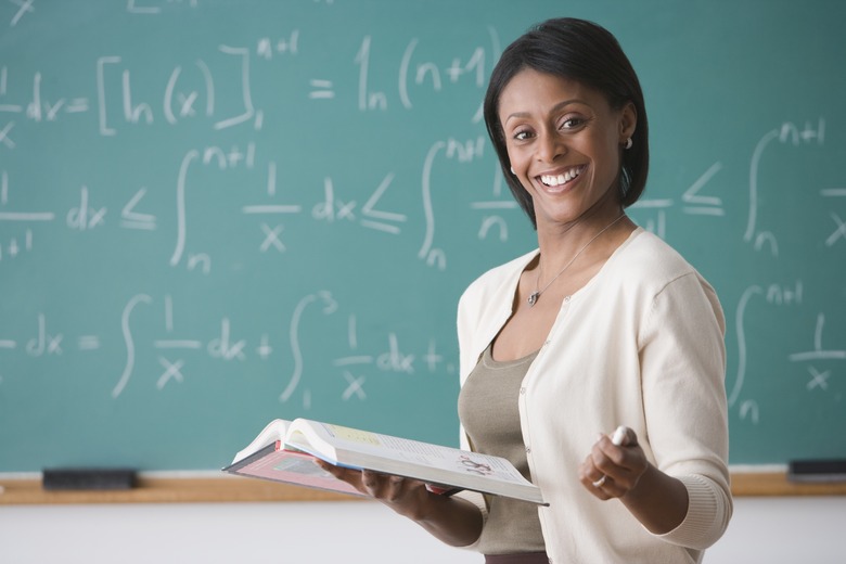 African American female teacher holding text book