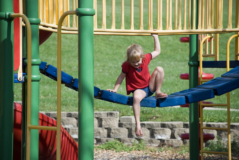 Girl playing on jungle-gym in park