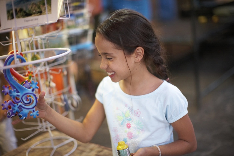 Girl (8-9) shopping at souvenir stall, outdoors