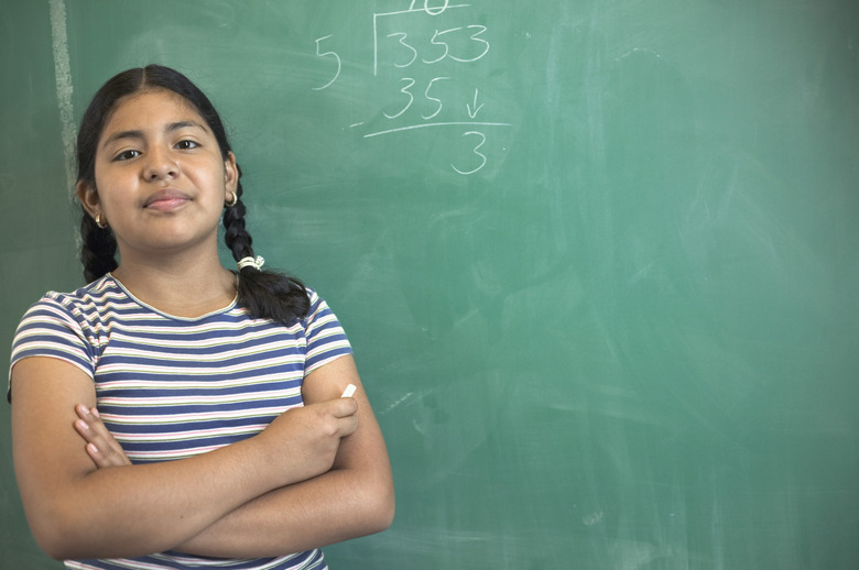 Girl standing by blackboard