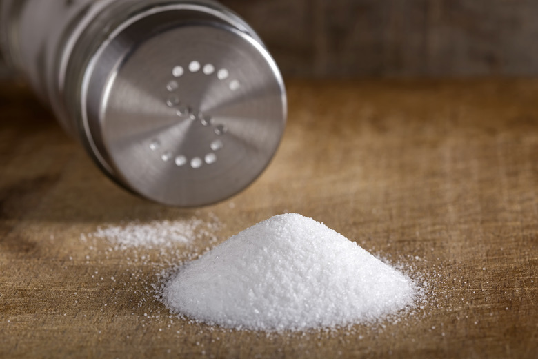 Salt spilling on table from salt cellar