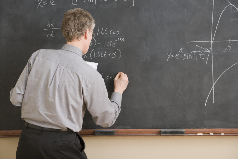 High School Teacher Writing Equation on Chalkboard