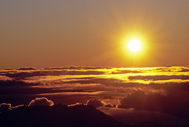 Hawaii, Sunball shining over clouds in dramtic sunset sky