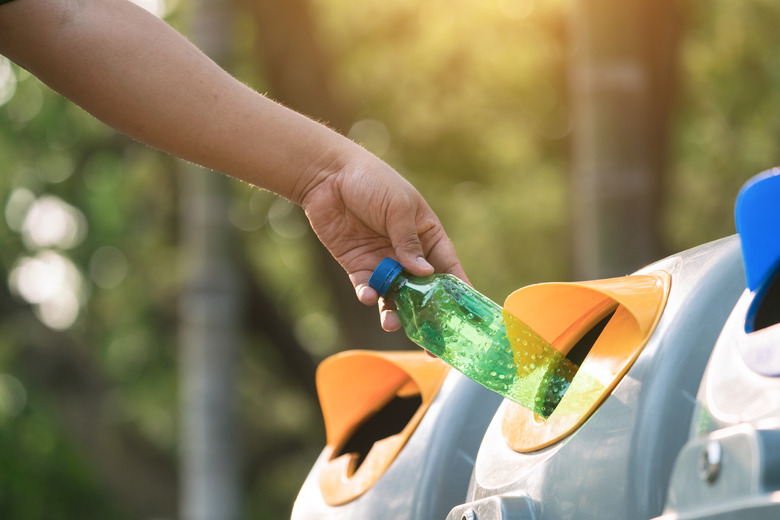 Close up hand throwing empty plastic bottle into the trash Recycling Concept