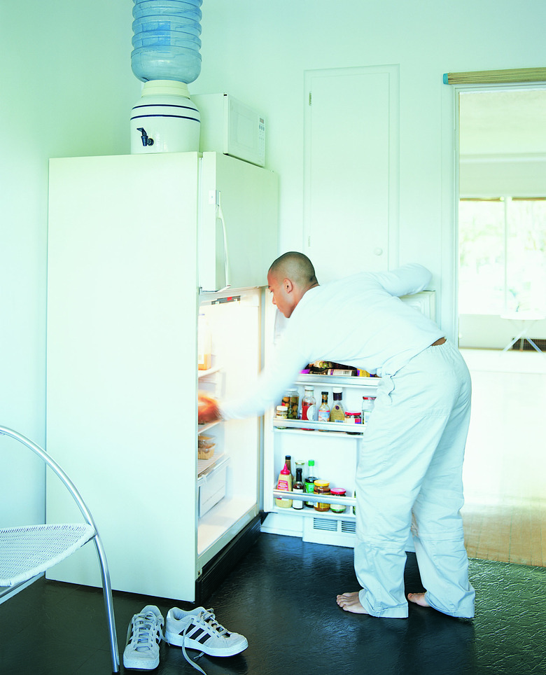 Young Man Getting Into Refrigertor