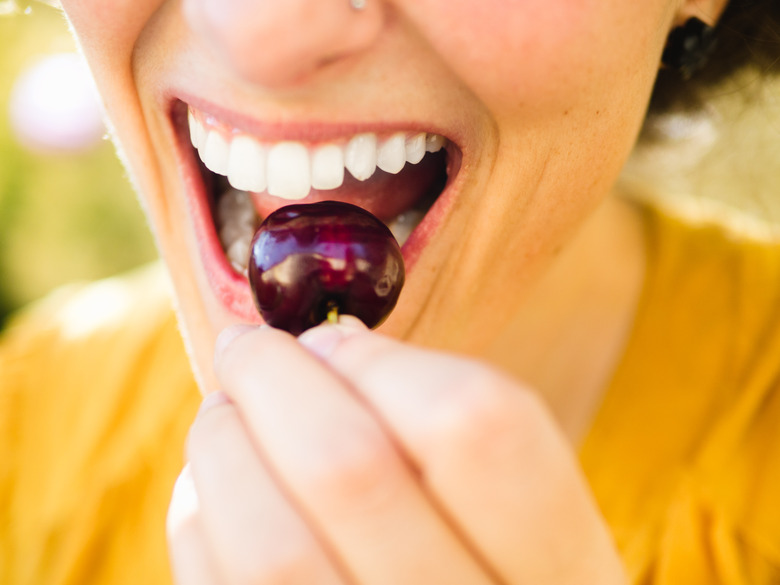 Woman biting a cherry