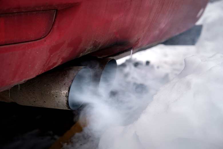 the exhaust gases of the car white thick smoke from the chimney in the winter