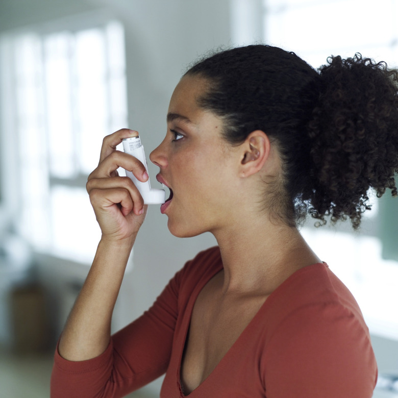 portrait of a young woman using an inhaler