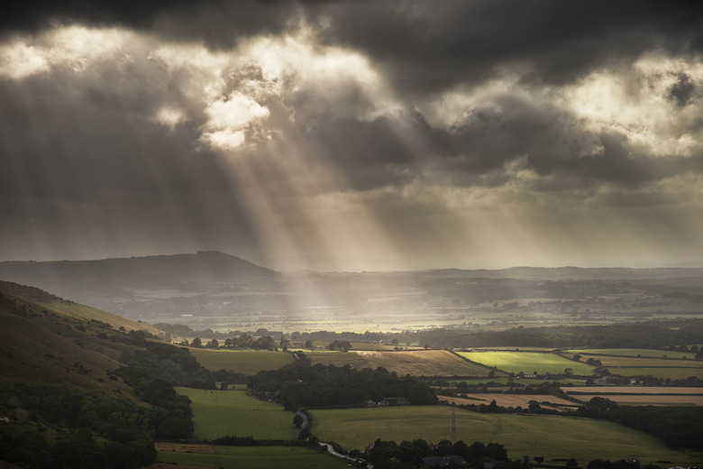 Stunning Summer landscape image of escarpment with dramatic storm clouds and sun beams streaming down