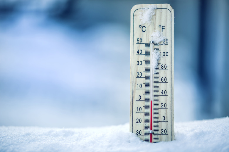 Thermometer on snow shows low temperatures - zero. Low temperatures in degrees Celsius and fahrenheit. Cold winter weather - zero celsius thirty two farenheit