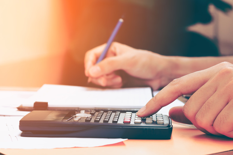 Close up young woman with calculator counting making notes