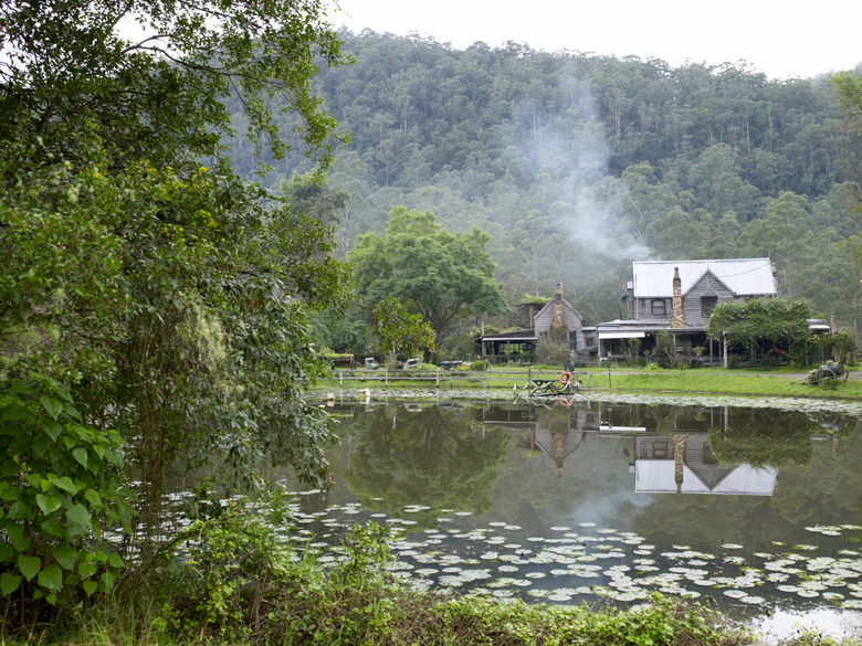 Country home on a pond with smoking chimney