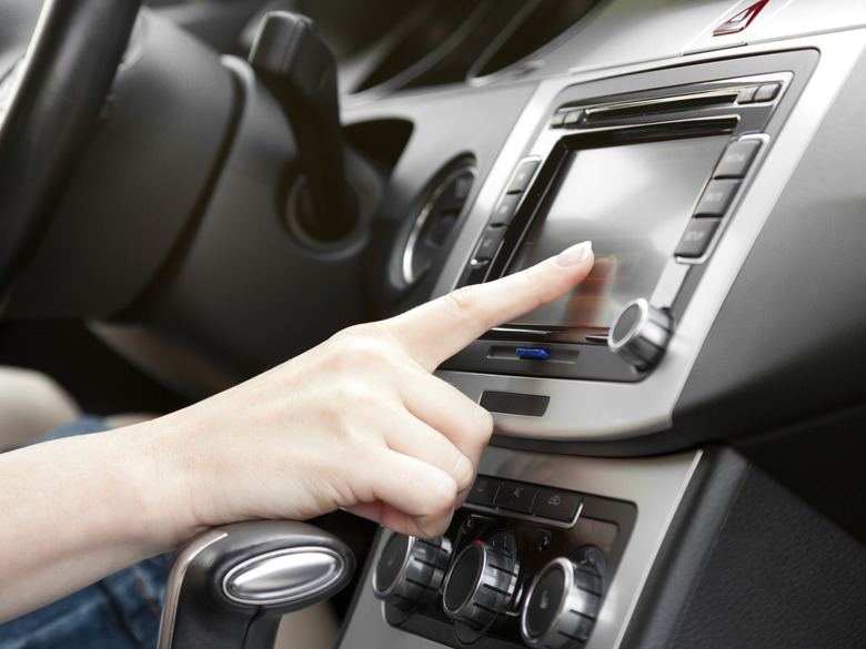 finger on dashboard with gps panel