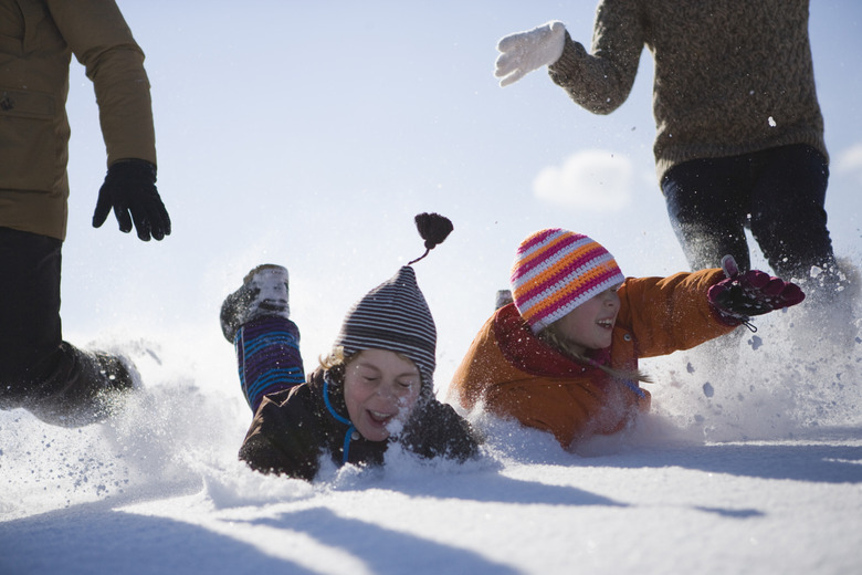 Boy and girl jumping into snow