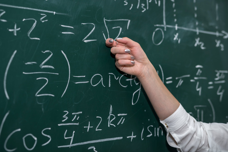 female hand showing math formula in chalkboard. Back to school