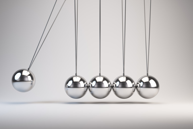 Silver balls of Newton's cradle swing back and forth