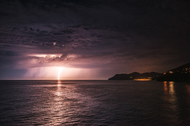 Lightning in the dark night sky over a sea