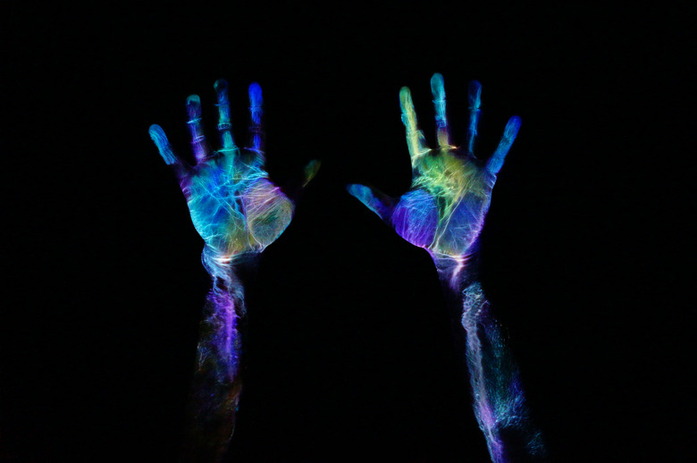 Neon paint on hands under fluorescent lighting