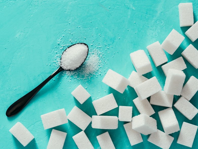 Top view of white sugar cubes on turquoise background