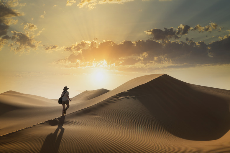 Woman on a sand dune at sunset