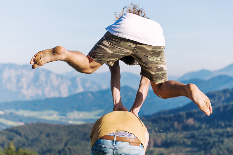 Austria, Mondsee, Mondseeberg, two young men leapfrogging