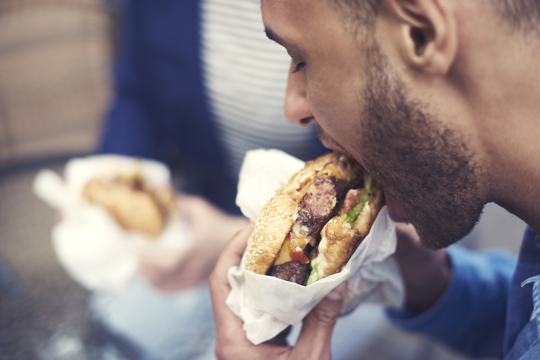 Close up of man eating cheeseburger