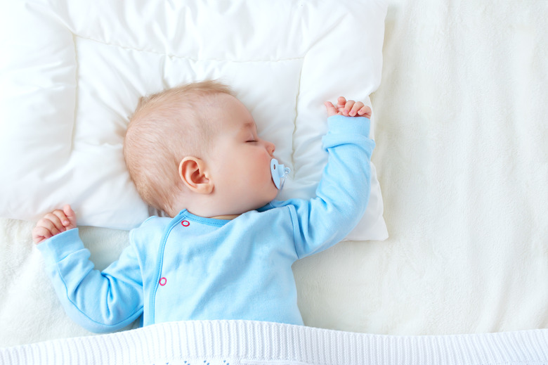 Baby in blue sleeping with a blanket