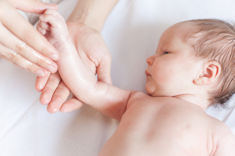 Mother makes massage for happy baby