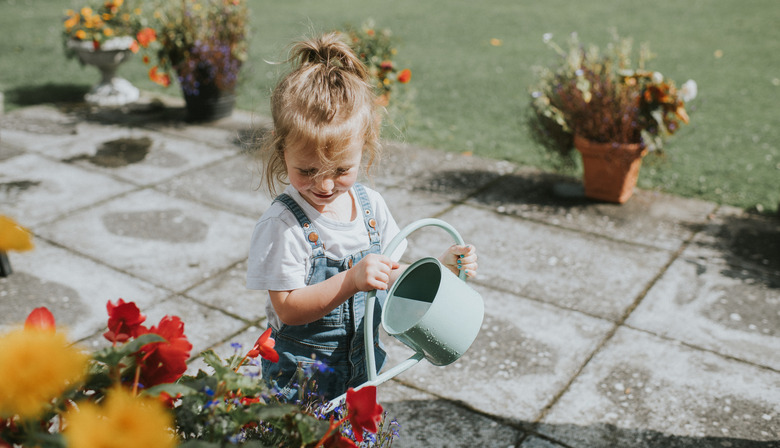 girl watering flowers with watering can