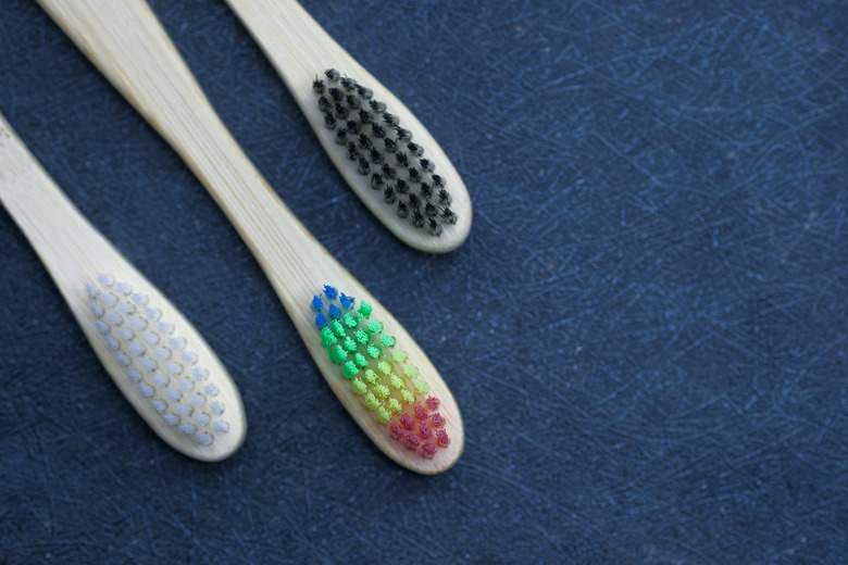 wooden tooth brushes on black background, top view