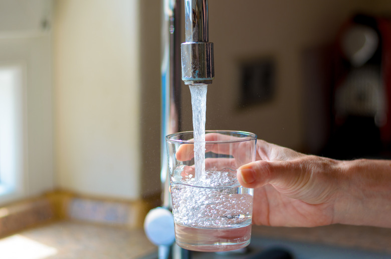 Woman filling a glass of water from a tap