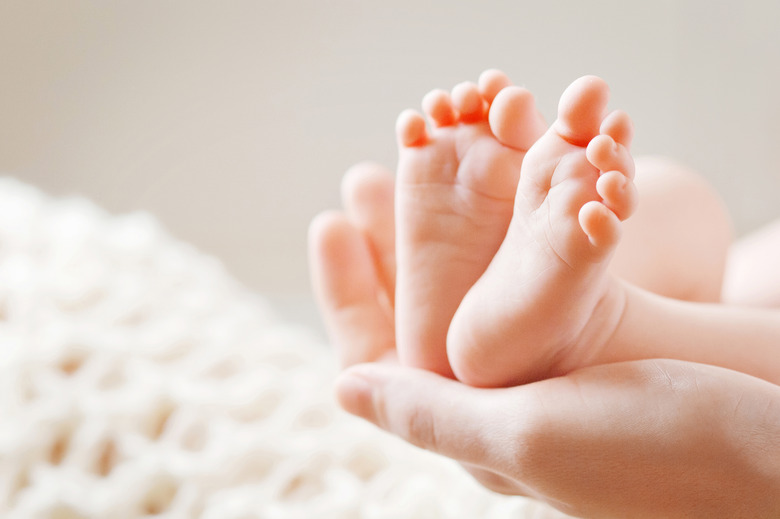 Baby feet in mother hands. Mom and her Child.