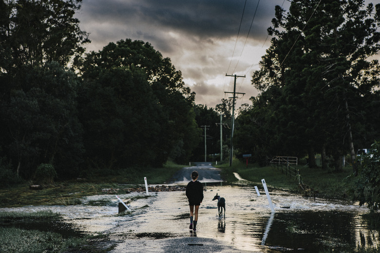 Girl walking on road after cyclone, Guanaba, Queensland, Australia