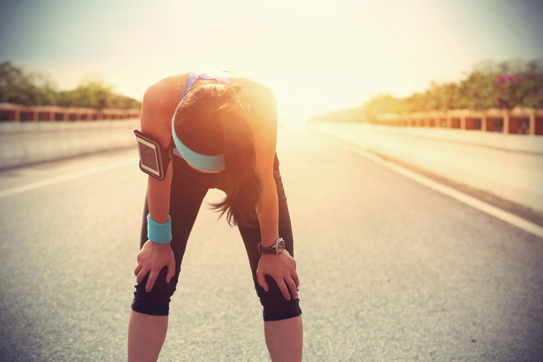 tired woman runner taking a rest after running hard