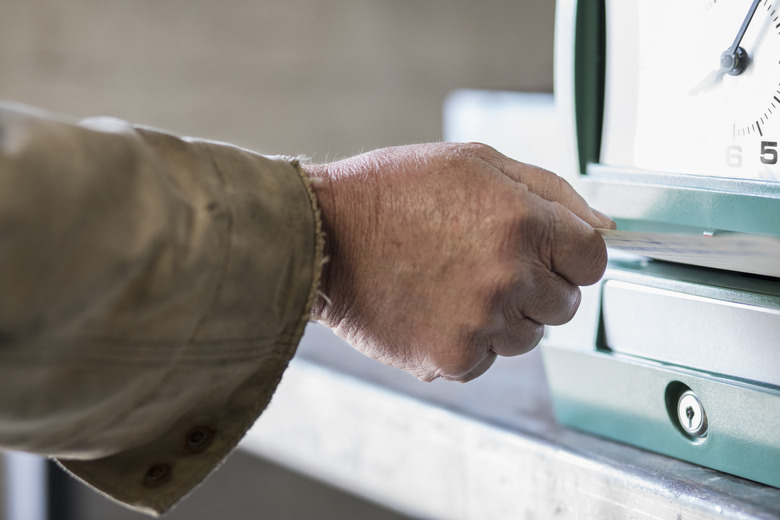 Caucasian worker punching time clock