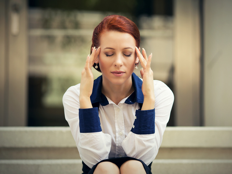 Woman under stress, sitting on steps of a building