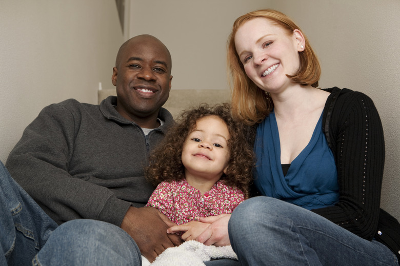 diverse family smile while sitting on steps